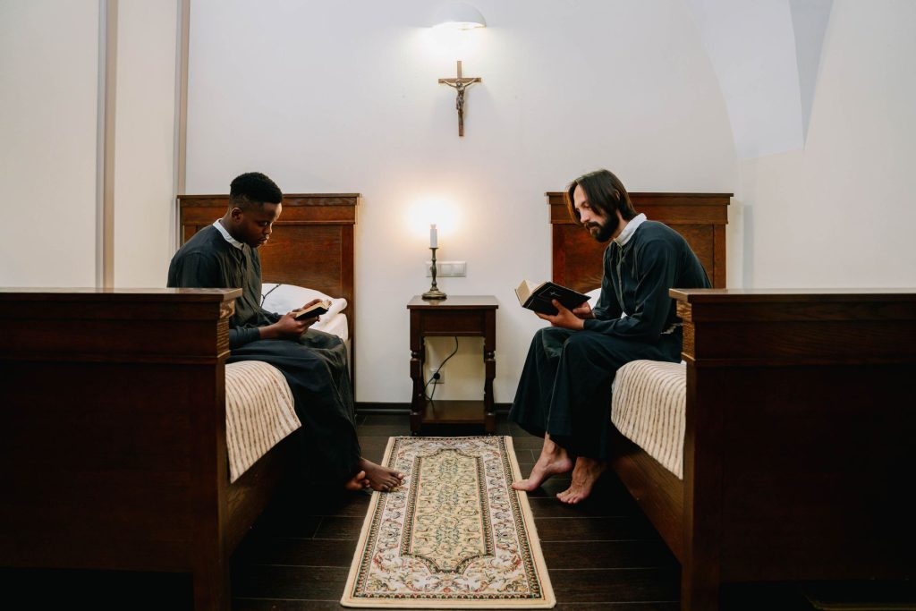 Two monks reading holy books in a serene monastery setting, reflecting faith and spirituality.
