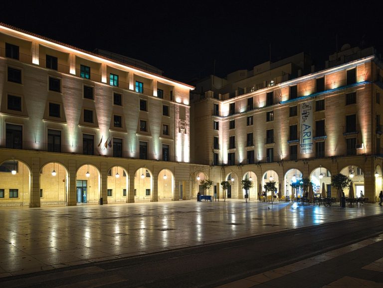 Elegant night view of Plaza de la Santísima Faz in Alicante, featuring illuminated historic buildings.