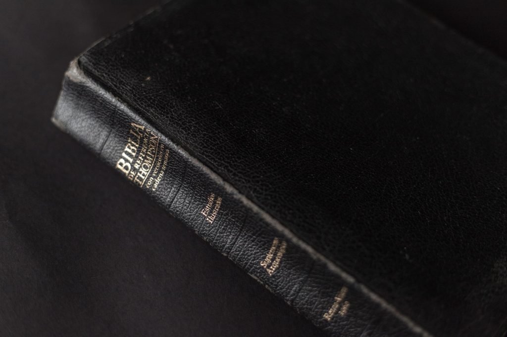 A black leather Bible with gold lettering on the spine, showcasing its textured cover.