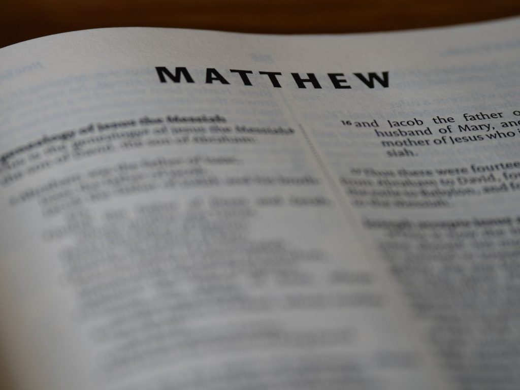 Close-up of an open Bible showing the Book of Matthew with selective focus.