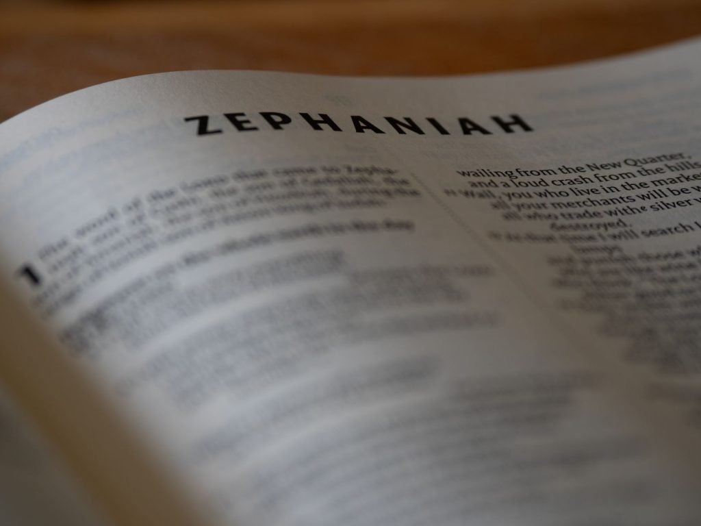 Close-up of an open Bible page highlighting the book of Zephaniah with selective focus.